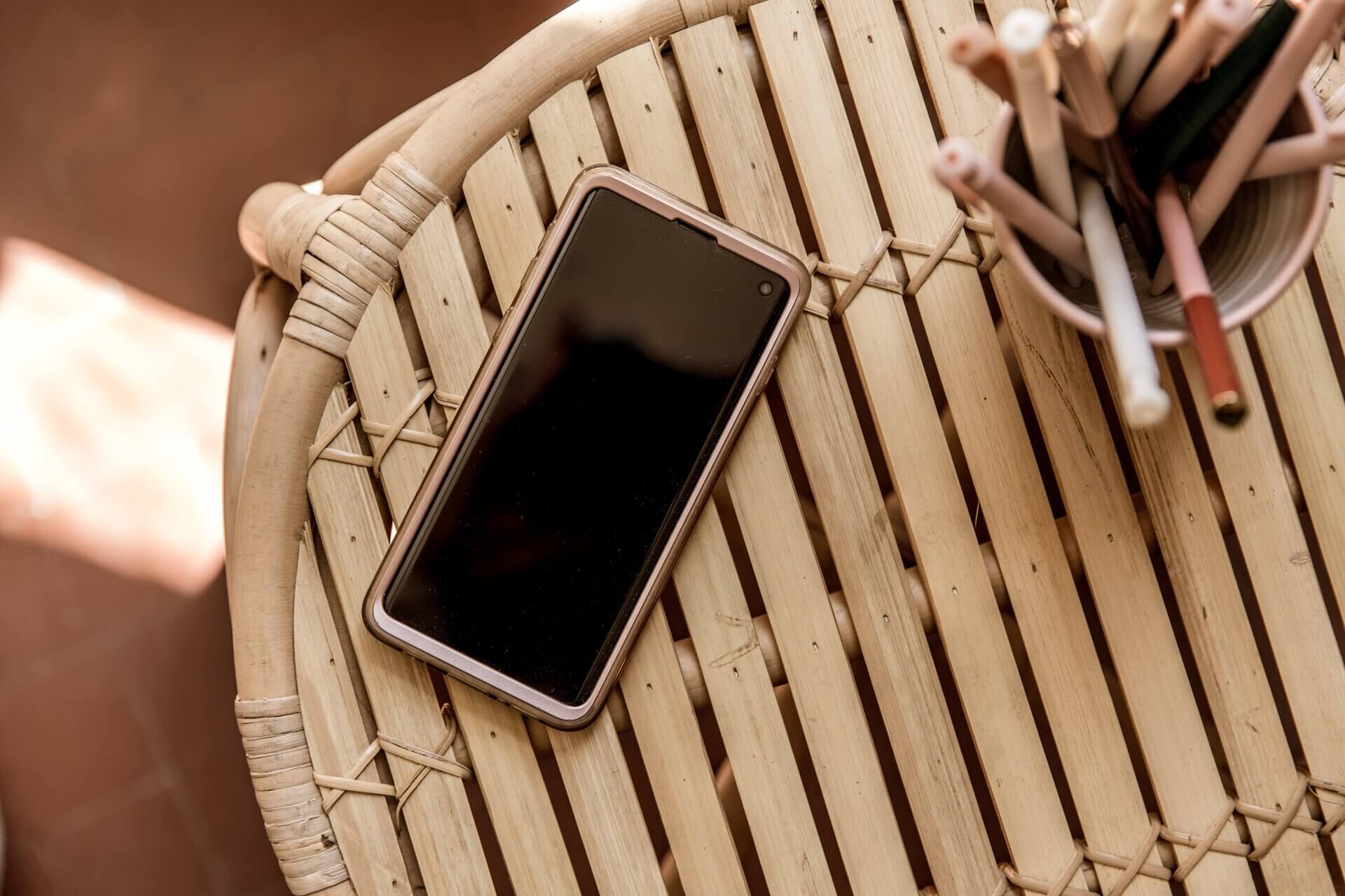 Phone on a wicker table that would be showing a contact page if I knew how to use Photoshop