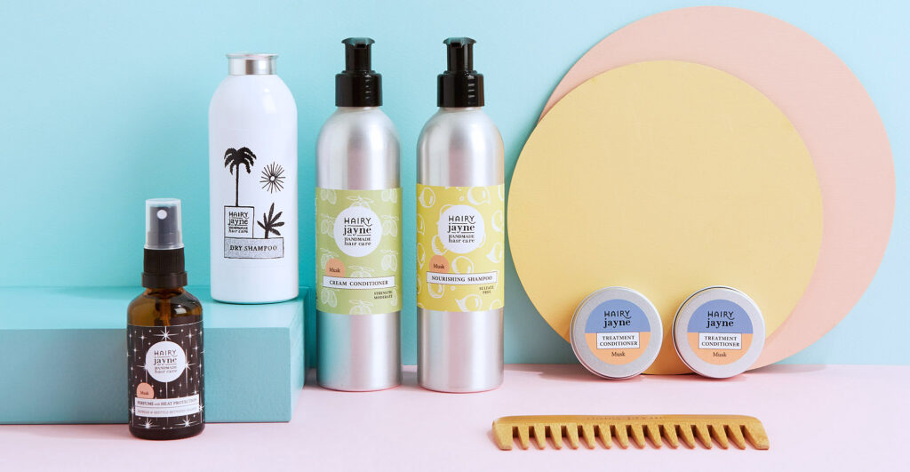 A selection of Hairy Jayne vegan hair care products, on a lovely pastel background