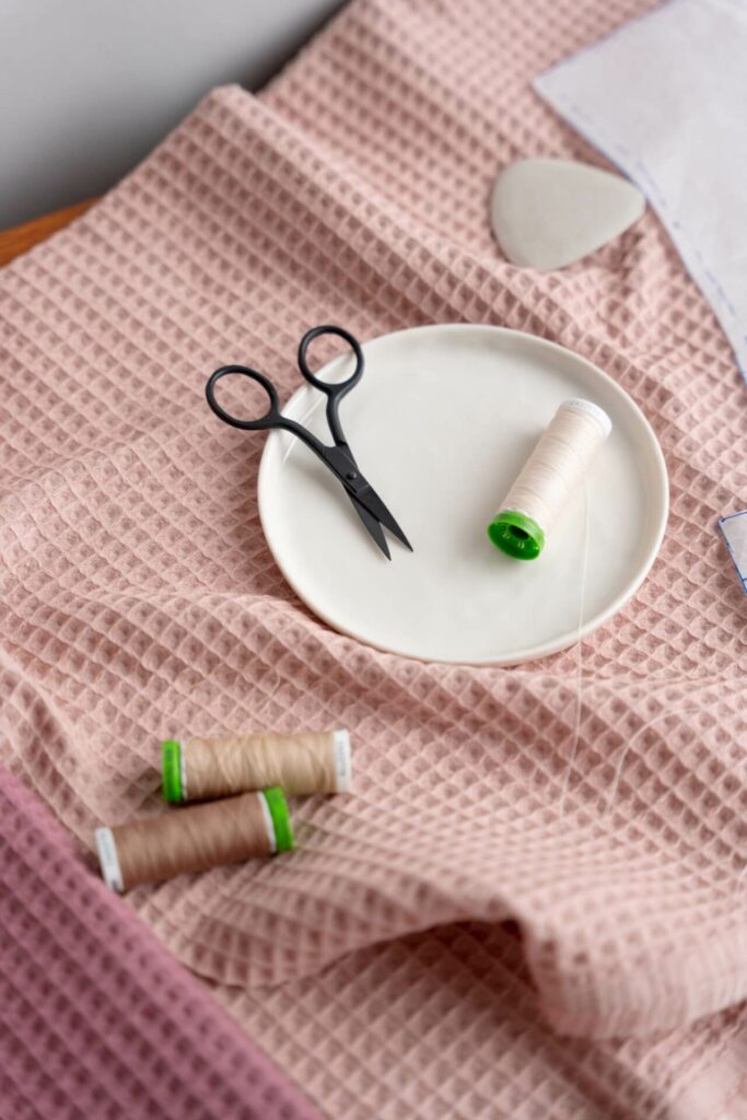 Good Fabric thread and scissors on pink waffle fabric