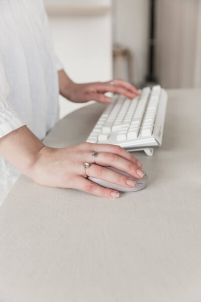 Hands typing on a keyboard and using a mouse.