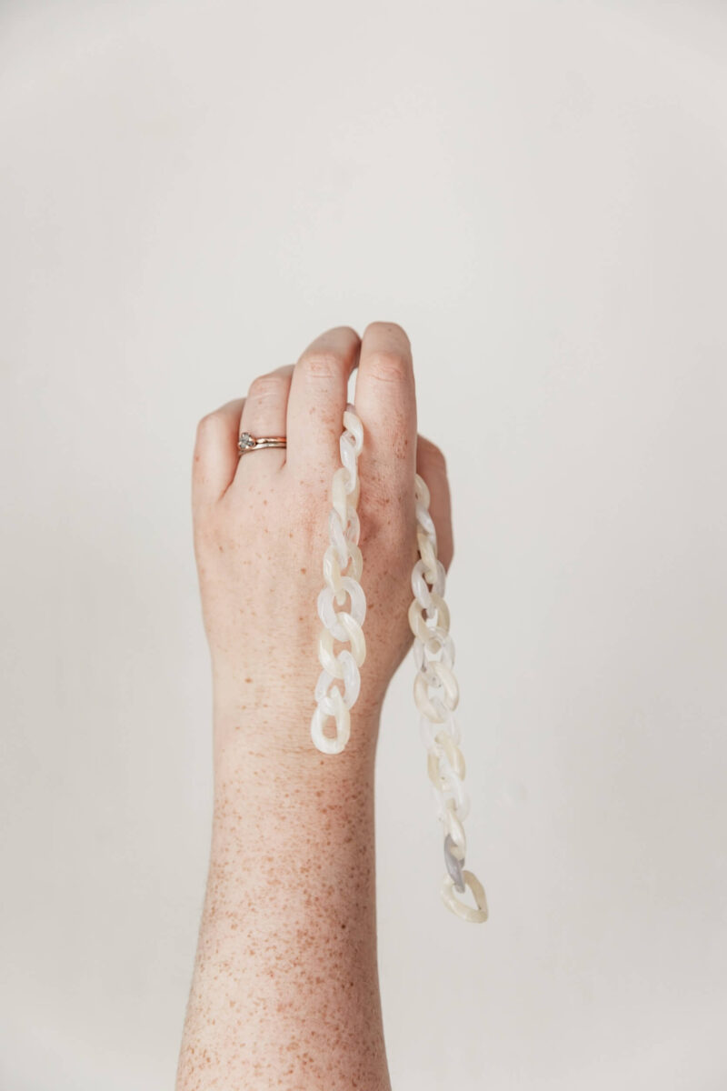 Studio Cotton Aime's hand holding up some links.