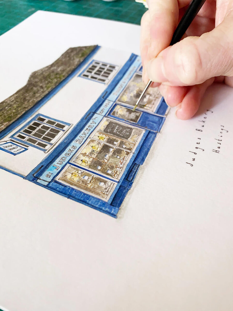 A hand painting the watercolour illustration of Judges Bakery