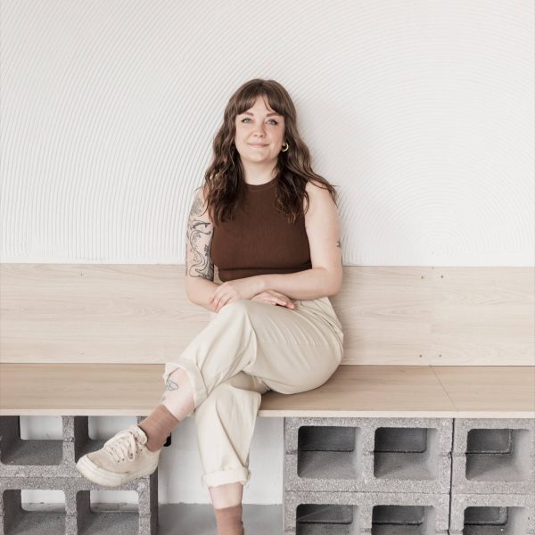 Studio Cotton's content producer Lyzi sat on a bench with crossed legs.